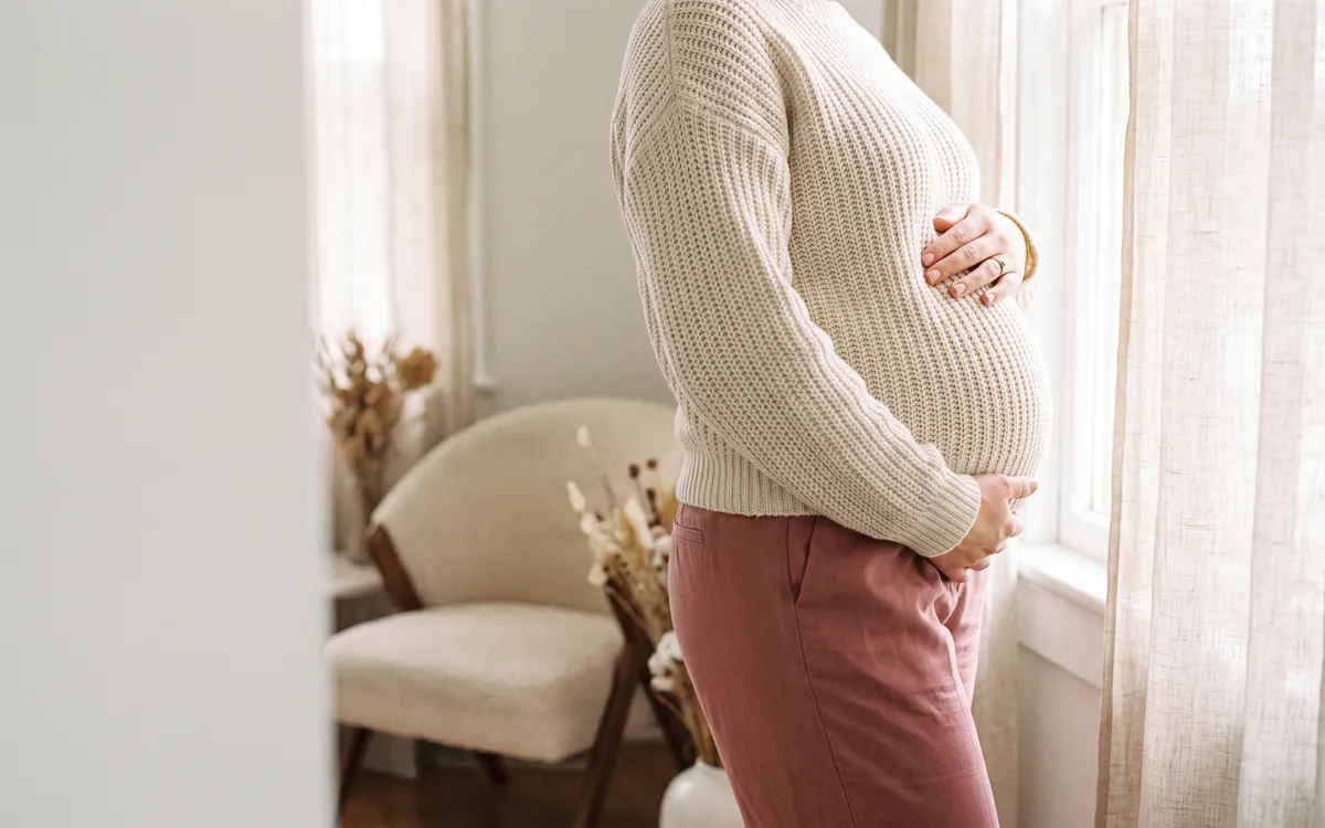 Future maman posant les mains sur son ventre, accompagnée par sa sage-femme